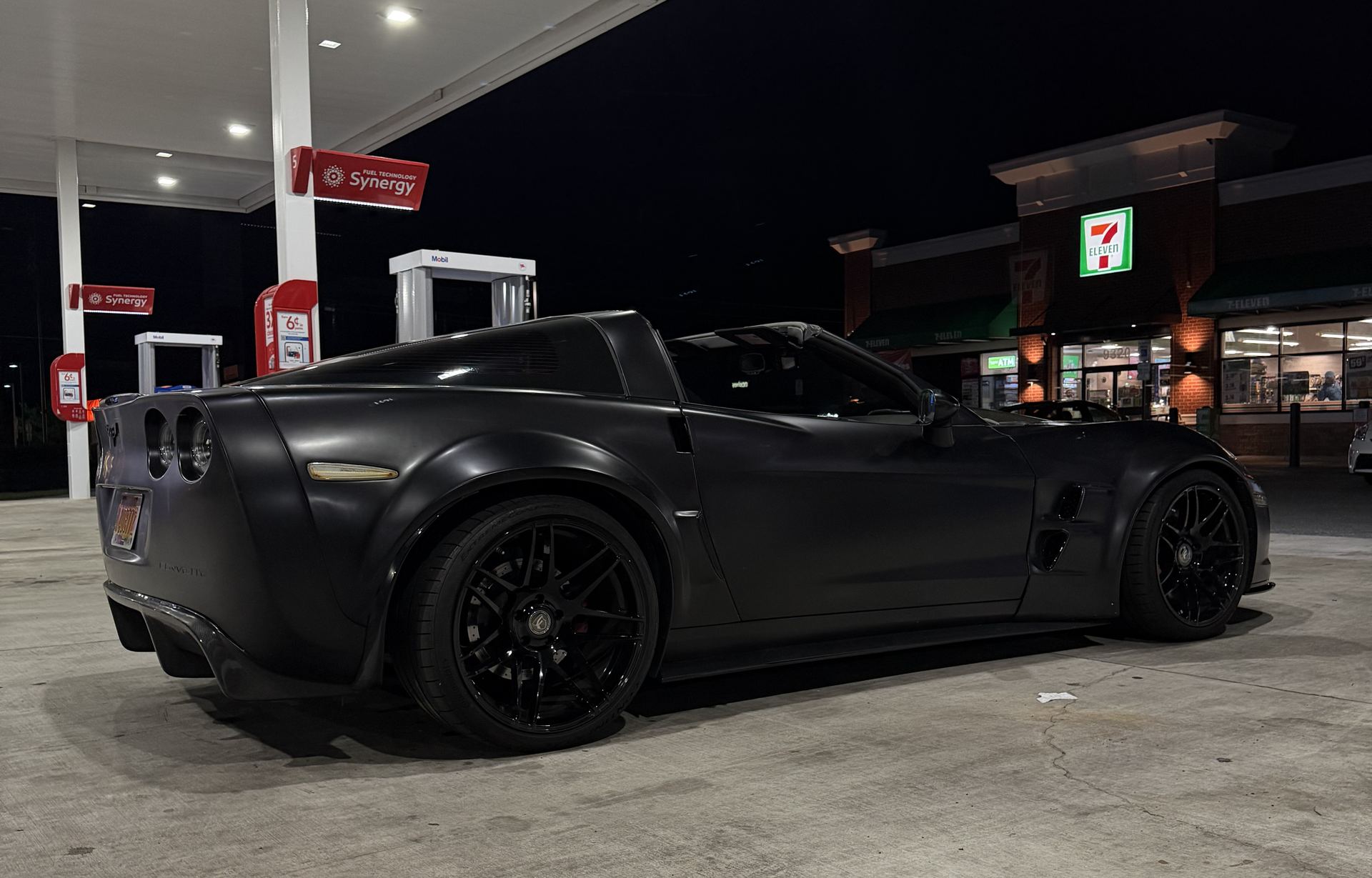 Widebody C6 Corvette under gas station lights at night